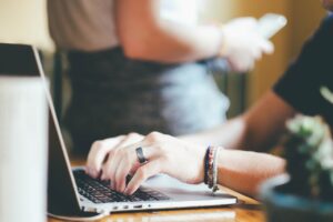 パソコンキーボードを打っている女性の手の画像